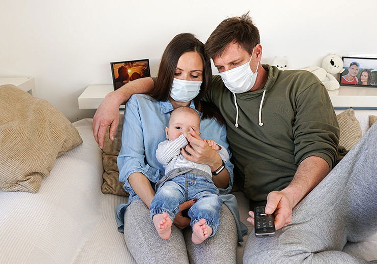 Coronavirus and air polution family concerned watching the news with masks