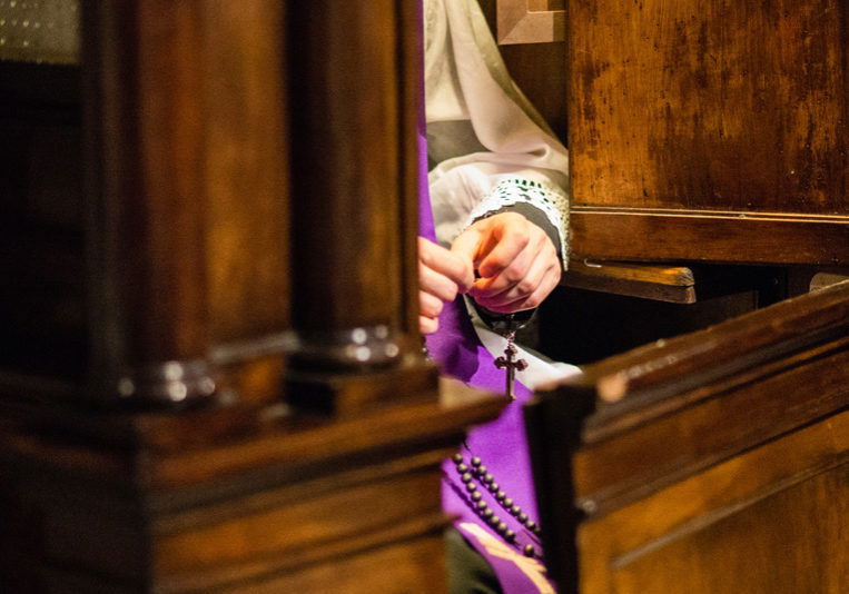 Priest in confessional